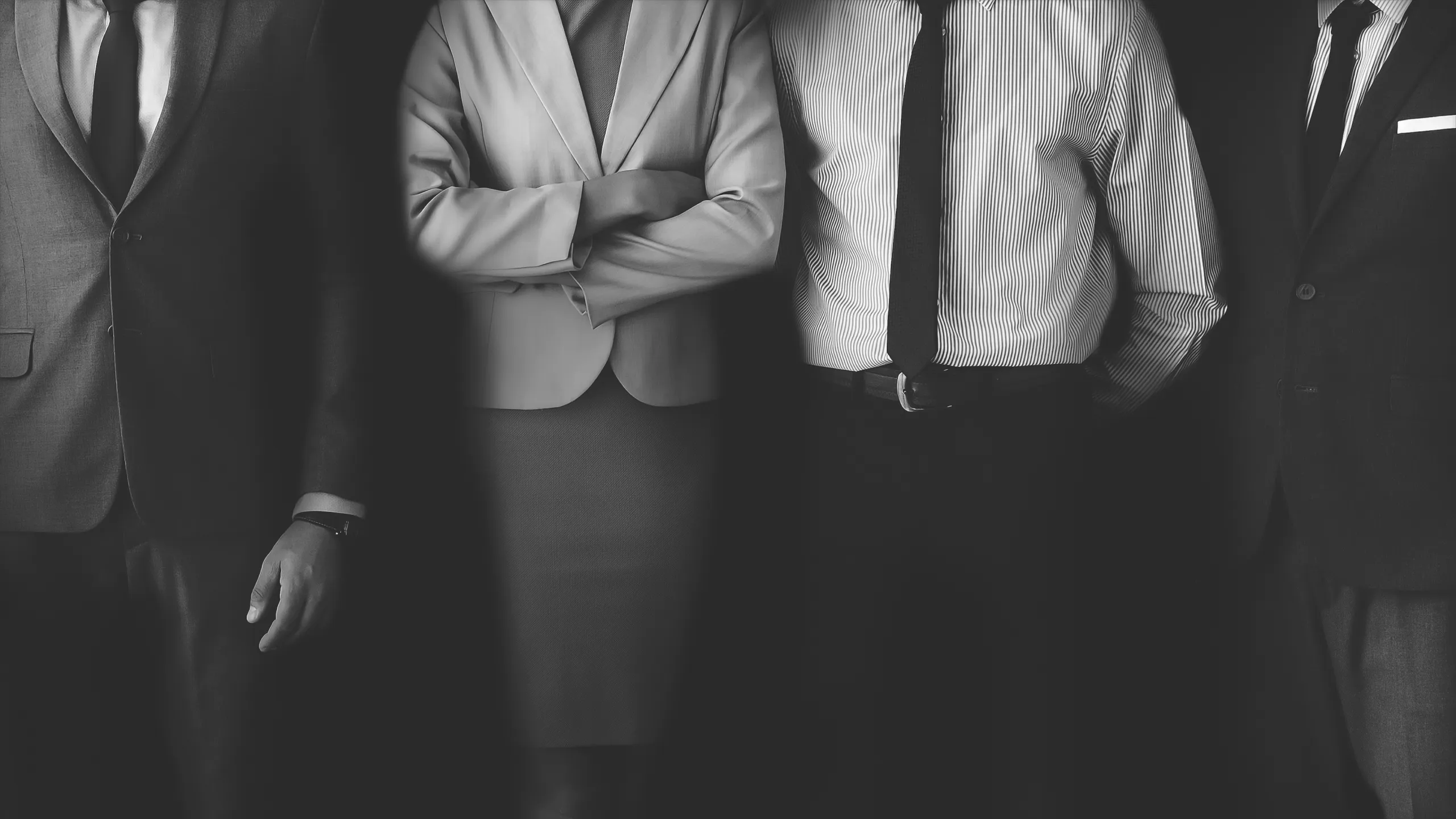 Gruppo di professionisti in piedi davanti a uno sfondo nero, promuovendo il bando per la parità di genere dell'Emilia Romagna.